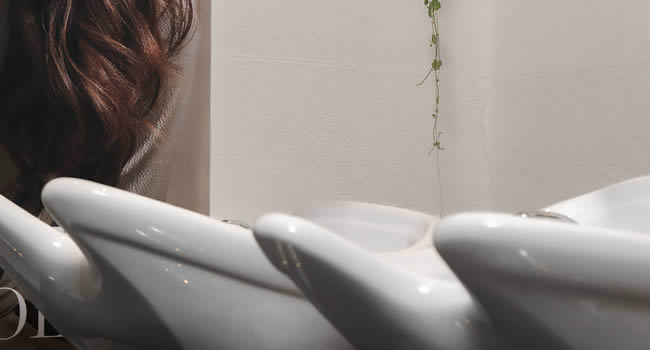 Waschbecken in einem Friseursalon mit Pflegeprodukten.